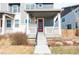 Inviting covered front porch with modern railings, and a striking red front door to welcome visitors at 21821 E 7Th Ave, Aurora, CO 80018