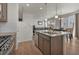 Modern kitchen with stainless steel appliances, a granite island, and beautiful hardwood floors throughout the space at 21821 E 7Th Ave, Aurora, CO 80018