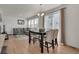 Bright living room featuring hardwood floors, a gray sofa, and a dining area with modern lighting at 21821 E 7Th Ave, Aurora, CO 80018