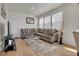 Well-lit living room with a comfortable gray sectional sofa, stylish rug, and multiple windows at 21821 E 7Th Ave, Aurora, CO 80018