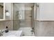 Bathroom featuring a shower-tub combo with glass doors and neutral tile surround at 30 Eudora St, Denver, CO 80220
