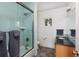 Well-lit bathroom featuring a shower-tub combo with glass doors and modern vanity at 30 Eudora St, Denver, CO 80220