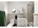 Well-lit bathroom with a single sink vanity, octagon window and glass-enclosed tub at 30 Eudora St, Denver, CO 80220