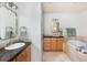 Bathroom features dual vanity, bathtub, and stone tile at 30 Eudora St, Denver, CO 80220