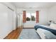 Bedroom with hardwood floors, a modern closet, and bright natural light from a large window at 30 Eudora St, Denver, CO 80220