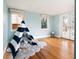 Bright bedroom with blue walls, hardwood floors, a striped teepee, two windows, and access to the patio at 30 Eudora St, Denver, CO 80220