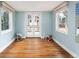 Bright bedroom with blue walls, hardwood floors, two windows, double glass doors, and a zebra-striped stool at 30 Eudora St, Denver, CO 80220