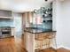 Bright kitchen boasts stainless appliances, blue backsplash, pendant lighting, and a breakfast bar with gold seating at 30 Eudora St, Denver, CO 80220