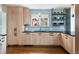 Modern kitchen featuring light wood cabinets, blue backsplash, black countertops, and stainless steel sink at 30 Eudora St, Denver, CO 80220