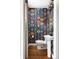 Chic powder room featuring hardwood floors, colorful patterned wallpaper, a pedestal sink, and a decorative mirror at 30 Eudora St, Denver, CO 80220