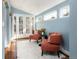 Cozy sitting room featuring two orange armchairs, a black accent table, soft white rug, and double glass doors at 30 Eudora St, Denver, CO 80220