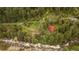 Aerial view of property nestled among trees, including outbuildings and a river along the property line at 35106 Boulder Canyon Dr, Boulder, CO 80302
