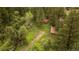 Aerial view of rustic cabin and buildings, surrounded by lush trees and greenery at 35106 Boulder Canyon Dr, Boulder, CO 80302