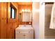 Bathroom featuring wood paneling, modern vanity, and ample lighting at 35106 Boulder Canyon Dr, Boulder, CO 80302
