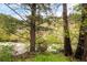 Scenic view of a lush landscape featuring a rushing stream and unique, rustic birdhouse at 35106 Boulder Canyon Dr, Boulder, CO 80302