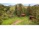 A lush and green wooded lot featuring a small home and metal outbuilding at 35106 Boulder Canyon Dr, Boulder, CO 80302