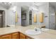 Bathroom featuring double sinks, a large mirror, and wooden storage cabinets at 9212 E Arbor Cir # E, Englewood, CO 80111