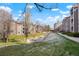 Condominium complex with green space, sidewalks, and mature landscaping, set against a blue sky with fluffy clouds at 9212 E Arbor Cir # E, Englewood, CO 80111