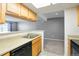 Bright kitchen featuring wooden cabinets, stainless steel sink, and sleek black appliances overlooking the living area at 9212 E Arbor Cir # E, Englewood, CO 80111