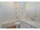 Bright bathroom with subway tile, a shower over tub, and vanity with white marble countertop at 8016 Gore Creek Ln, Littleton, CO 80125