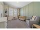 Bedroom with gray glider, crib, and soft green accent wall at 8016 Gore Creek Ln, Littleton, CO 80125