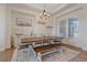 Bright dining room with large window, stylish chandelier, and farmhouse-style dining table and bench at 8016 Gore Creek Ln, Littleton, CO 80125