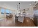 Modern kitchen with white cabinets, stainless steel appliances, large center island, and hardwood floors at 8016 Gore Creek Ln, Littleton, CO 80125