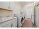 Laundry room with modern washer and dryer, sink, storage cabinets, and wood-look floors at 8016 Gore Creek Ln, Littleton, CO 80125
