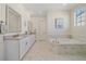Bright bathroom with marble floors, double vanity, standalone tub, and modern fixtures at 8016 Gore Creek Ln, Littleton, CO 80125