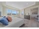 Bright main bedroom featuring large windows, tray ceilings, neutral colors, and a dresser at 8016 Gore Creek Ln, Littleton, CO 80125