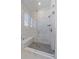 Shower stall with marble tile, glass enclosure, bench seating, and modern fixtures at 8016 Gore Creek Ln, Littleton, CO 80125
