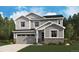 Charming two-story home with gray siding, stone accents, a well-manicured lawn and a two car garage at 245 Wooten Ave, Brighton, CO 80601