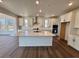 A modern kitchen with stainless steel appliances, white cabinets, and a spacious island with quartz countertops at 245 Wooten Ave, Brighton, CO 80601