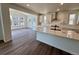 A modern kitchen with stainless steel appliances, white cabinets, and a spacious island with quartz countertops at 245 Wooten Ave, Brighton, CO 80601