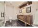 Modern bathroom with a custom wood vanity, marble countertop, and designer fixtures at 6435 Spotted Fawn Run, Littleton, CO 80125