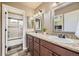 A bathroom with a double sink, granite countertop, and a view of the mountains in the background at 6435 Spotted Fawn Run, Littleton, CO 80125