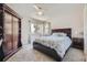 A bright bedroom with a ceiling fan, large window, and an ornate wooden wardrobe at 6435 Spotted Fawn Run, Littleton, CO 80125