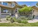 Beautiful front entrance with a well-manicured landscape, stone accents, and a charming walkway at 6435 Spotted Fawn Run, Littleton, CO 80125