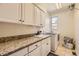Bright laundry room features granite countertops, basin sink, washer, and dryer at 6435 Spotted Fawn Run, Littleton, CO 80125