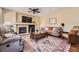 A living room featuring a fireplace, a ceiling fan, and a comfortable seating arrangement at 6435 Spotted Fawn Run, Littleton, CO 80125