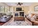 A living room featuring a fireplace, a ceiling fan, and comfortable seating at 6435 Spotted Fawn Run, Littleton, CO 80125