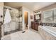 Inviting main bathroom with glass shower, soaking tub, and granite vanity at 6435 Spotted Fawn Run, Littleton, CO 80125