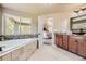 Bright main bathroom features a tub, granite vanity, and an open doorway at 6435 Spotted Fawn Run, Littleton, CO 80125