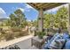 An outdoor patio featuring comfortable seating, a grill, and views of a landscaped yard at 6435 Spotted Fawn Run, Littleton, CO 80125