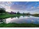 Scenic pond reflecting sky, trees, and red rock formations, offering tranquility at 6435 Spotted Fawn Run, Littleton, CO 80125