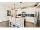 Modern kitchen featuring granite countertops, a central island, and sleek, white cabinetry at 17720 Weymouth Ave, Parker, CO 80134