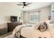 Comfortable bedroom with a large bed, neutral decor, ceiling fan, and bright natural light at 17720 Weymouth Ave, Parker, CO 80134