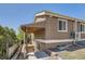 View of house featuring covered porch and walkout basement with retaining wall at 2060 W Iliff Ave, Englewood, CO 80110