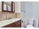 Practical bathroom with a vanity, decorative mirror, tiled walls, and essential fixtures at 2060 W Iliff Ave, Englewood, CO 80110