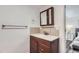 Bathroom vanity with wood cabinets, white counter, and mirror with a view of the bedroom at 2060 W Iliff Ave, Englewood, CO 80110